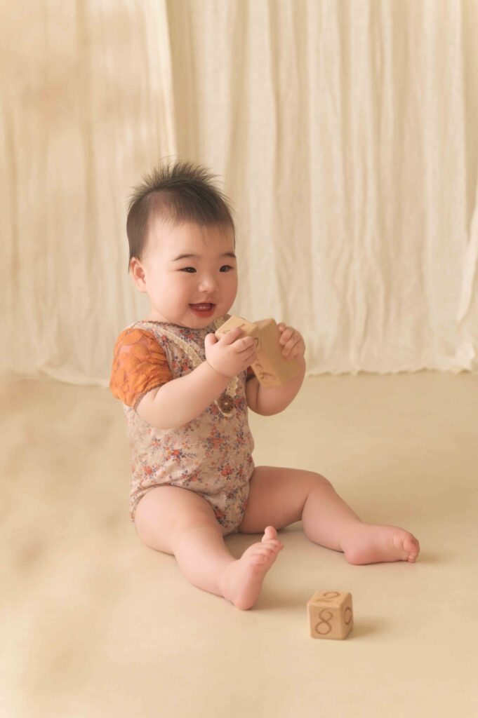 愛知県豊橋市のニューボーンフォト専門スタジオリアンです。ハーフバースデー、1歳誕生日で使えるベビーレンタル衣装のご紹介をします。ベビー用レンタル衣装18。ベージュカラーのふわもこロンパース。くま耳のボンネットがポイント！海外から輸入したこだわりの衣装を着て撮影したいと、名古屋・岡崎方面からもご来店多数いただいています。